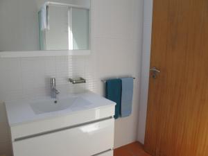 a white bathroom with a sink and a mirror at Casa do Cais Cerveira in Vila Nova de Cerveira +42 photos