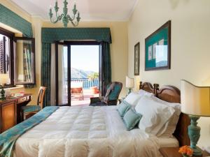 a bedroom with a large bed and a balcony at Hotel Sirius in Taormina