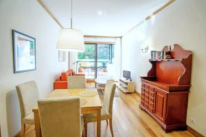 a dining room with a table and chairs and a living room at Quinta Miramar in Funchal