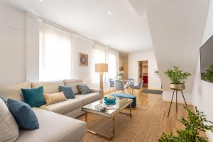 ein Wohnzimmer mit einem Sofa und einem Tisch in der Unterkunft Genteel Home Francos in Sevilla