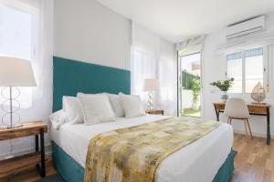 1 dormitorio con 1 cama grande, mesa y sillas en Genteel Home Francos, en Sevilla