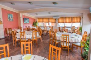 a restaurant with white tables and chairs and windows at Lafodija in Međugorje
