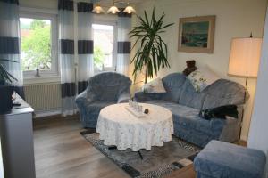 un soggiorno con divano, 2 sedie e tavolo di Haus Christa a Langelsheim