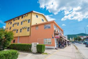 a yellow and orange building on the side of a street at Lafodija in Međugorje