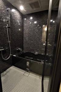 a bathroom with a shower, sink, and tub at Nagi Kyoto Sanjo in Kyoto