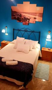 um quarto com uma grande cama branca com paredes azuis em RINCON DO MAR 1 IZ em A Guarda