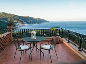 a table and chairs on a balcony with the ocean at Hotel Sirius in Taormina
