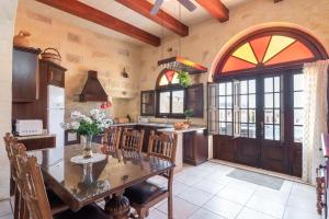 a kitchen with a table and chairs in a room at Villayana Holiday Home in San Lawrenz