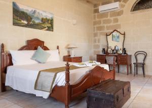 a bedroom with a bed with a table and a desk at Villayana Holiday Home in San Lawrenz +71 photos