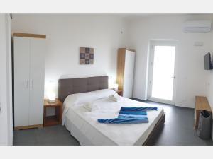 ein Schlafzimmer mit einem Bett und einem blauen Handtuch darauf in der Unterkunft Medusa room apartment in Porto Cesareo