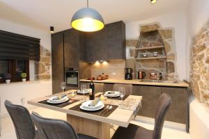 een keuken met een tafel en stoelen en een keuken met een aanrecht bij House Anika in Šilo