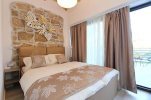 um quarto com uma cama e uma parede de pedra em House Anika em Šilo