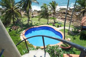 balcone con vista sulla piscina di un resort di Villa Lucky Star a Tangalle