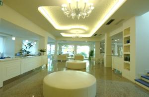a large lobby with a chandelier and a table and chairs at Hotel Sport & Residenza in Cesenatico +47 photos