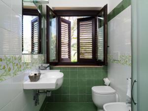 a bathroom with a sink and a toilet and a window at Hotel Sirius in Taormina