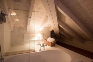 a bathroom with a large tub in a attic at Art Hotel Varese in Varese +29 photos