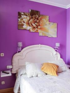 um quarto com uma cama branca e uma parede roxa em RC Miguel Angel em Madri