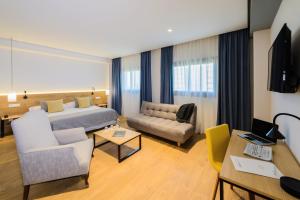 a hotel room with a bed and a couch at Hotel Aida in Torrejón de Ardoz