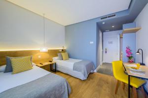 a hotel room with two beds and a desk at Hotel Porcel Aida in Torrejón de Ardoz +24 photos