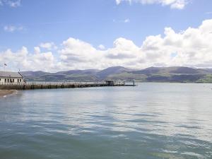 a pier on a lake with a train on it at The Coach House - Beaumaris in Beaumaris +6 photos