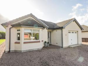 a small white house with a garage at Number 11 in Beauly