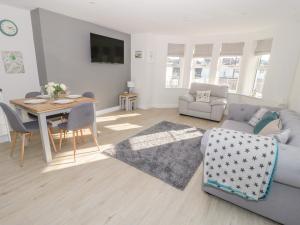 uma sala de estar com uma mesa e um sofá e uma sala de jantar em Hafan Traeth Beach Haven em Benllech