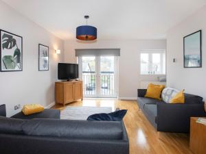 a living room with two couches and a tv at Coed y Felin in Conwy