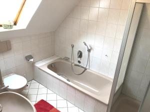 a bathroom with a tub and a toilet at Holiday Rügen Putbus in Putbus