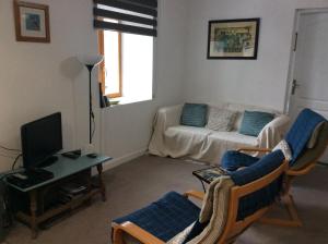 a living room with a couch and a tv at Number 7 Gouarec in Gouarec +36 photos