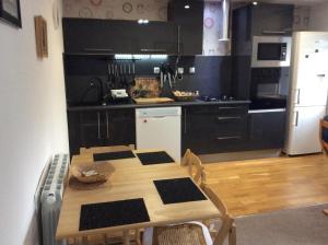 a kitchen with a wooden table and a kitchen with black cabinets at Number 7 Gouarec in Gouarec