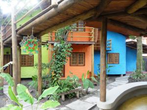 a colorful house with a bench in front of it at Pousada Aldeia in Ilha de Boipeba