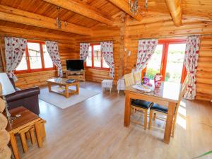 un soggiorno con divano e tavolo in una cabina di Ash Lodge a Oakham