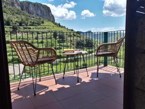 Dos sillas y una mesa en un balcón con vista. en B&B Taccu Maccu, en Ulassai