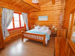 Un dormitorio con una cama en una cabaña de troncos en Yew Lodge, en Oakham 38 fotos más
