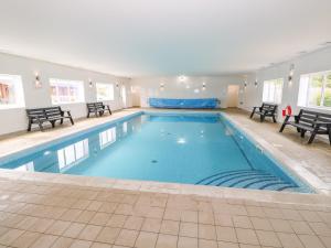 Una gran piscina con agua azul en un edificio. en Yew Lodge, en Oakham
