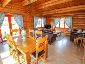comedor y sala de estar en una cabaña de madera en Yew Lodge, en Oakham