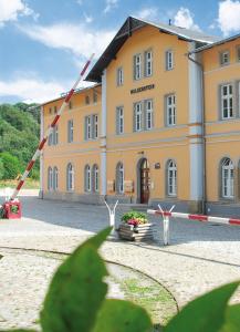 a large yellow building with a building at Wolkensteiner Zughotel in Wolkenstein