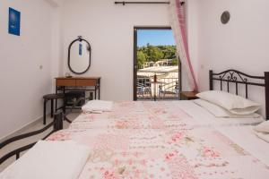 1 dormitorio con 2 camas y ventana con mesa en Plessas Studios, en Tsilivi