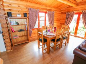 a dining room with a table and chairs in a log cabin at Sycamore Lodge in Oakham