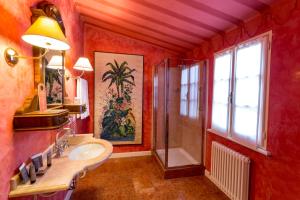 baño rojo con lavabo y ducha en Palazzo Dalla Rosa Prati, en Parma