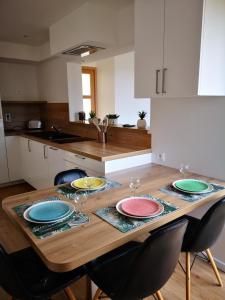 a wooden table with plates on it in a kitchen at L'horizon - Bord de mer in Ploemeur