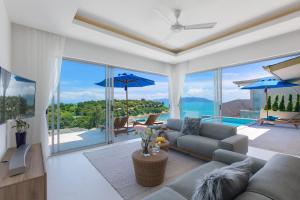 a living room with a couch and a pool at Single Level BEACHSIDE VILLA - BB2 - at BAYSIDE LUXURY VILLAS Samrong Bay Beach, 3 BED 4 BATH, SEA and SUNSET VIEWS, only 200m walk to the Beach in Bang Rak Beach