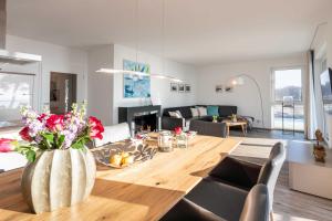 une salle à manger et un salon avec une grande table en bois dans l'établissement Appartement "Dünentraum" - Oase am Haff, à Garz