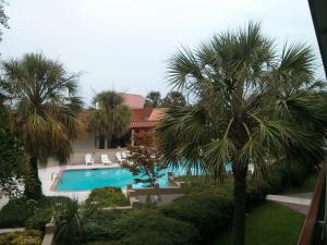 a swimming pool with two palm trees and a house at Motel 6-Florence, SC in Florence
