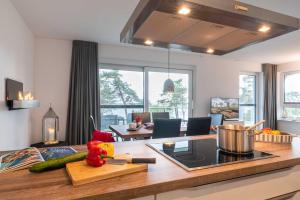 a kitchen with a counter with vegetables on a cutting board at Appartement "Opal" mit Penthouseflair - Oase am Haff in Garz