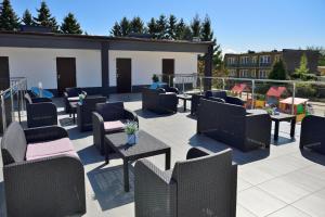 a patio with chairs and tables on a building at Błekitne Tarasy in Ustronie Morskie