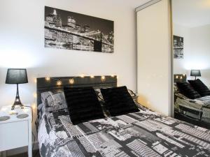 Schlafzimmer mit einem schwarzen und weißen Bett und einem Spiegel in der Unterkunft Cysgod Y Capel in Benllech