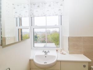 a white bathroom with a sink and a window at Wyebrow Cottage in Bakewell +31 photos