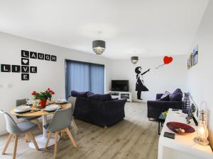 a living room with a couch and a table at Cysgod Y Capel in Benllech