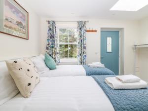 two twin beds in a room with a window at Wyebrow Cottage in Bakewell